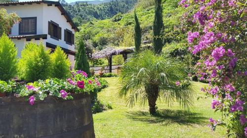 a garden with flowers and a house in the background at Quinta O Refúgio in São Vicente