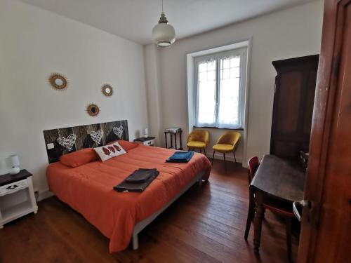 ein Schlafzimmer mit einem großen Bett mit einer orangefarbenen Decke in der Unterkunft Maison bretonne traditionnelle in Perros-Guirec