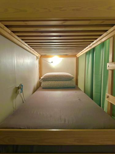 a bed in a tiny house with a light on it at One House in Gongliao