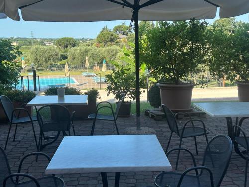 a patio with tables and chairs and a pool at Al Colle in Cavaion Veronese