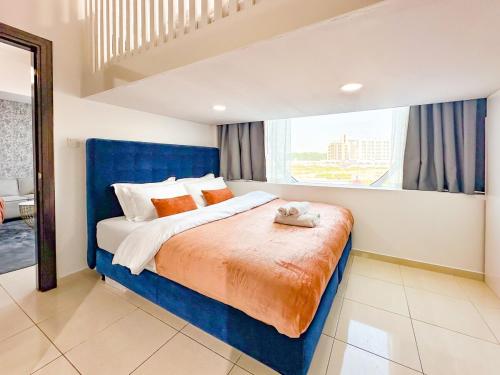 a bedroom with a large bed with a blue headboard at Amazing 2 Bedroom in Al Rabia Tower in Majan 6PPL in Dubai