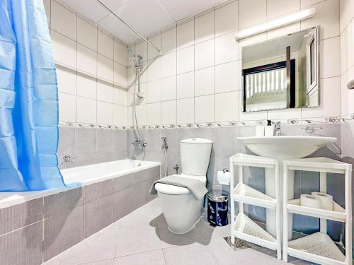 a white bathroom with a toilet and a sink at Amazing 2 Bedroom in Al Rabia Tower in Majan 6PPL in Dubai