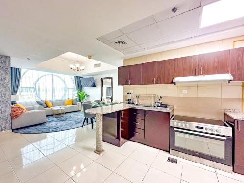 an open kitchen and living room with a couch at Amazing 2 Bedroom in Al Rabia Tower in Majan 6PPL in Dubai