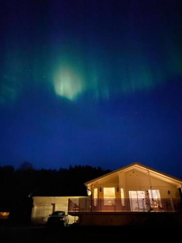 a house with the aurora in the sky at Brygghaugen, middle of Senja in Senja
