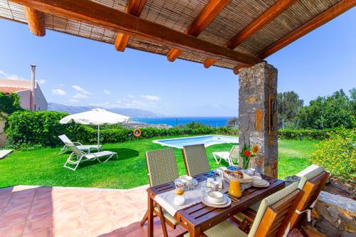 a patio with a table and chairs and a pool at Sissi Hills Villa in Sissi