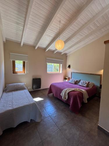 a bedroom with two beds and a ceiling at Cabañas Tierra Verde in El Bolsón
