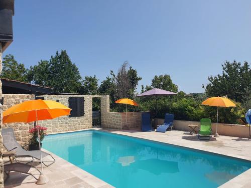 - une piscine avec 2 parasols et des chaises dans l'établissement Holidayhomepoujol mobile gite, à Montfermier