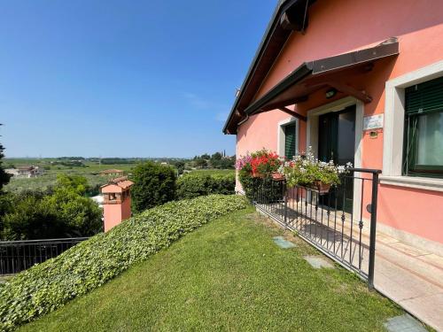 a pink house with flowers on a balcony at Al Colle in Cavaion Veronese