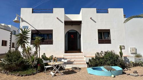 a white house with a table in front of it at Casa Olga in Caleta de Sebo