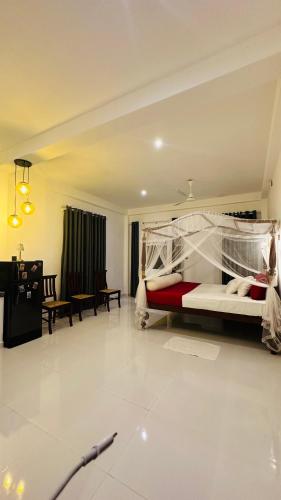 a bedroom with a bed and a living room at Villa J Ambalangoda in Ambalangoda
