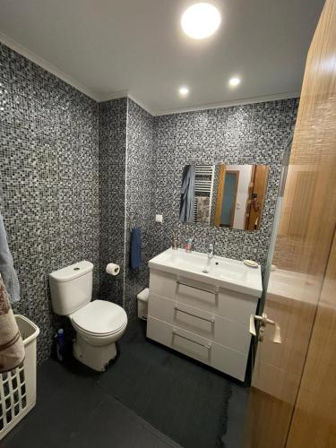 a bathroom with a toilet and a sink and a mirror at Montijo Lux & Design Apartment in Montijo