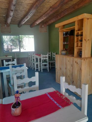 a room with white chairs and a table with a red blanket at 4 ELEMENTOS in Huacalera
