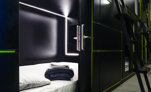 a black room with a bed and a door with towels at Hostel Joy Calle 85 in Bogotá