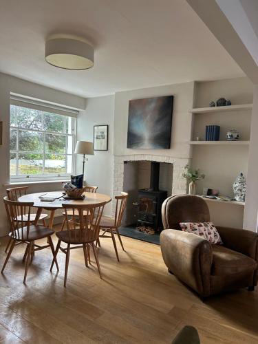 a living room with a table and chairs and a fireplace at Billie's seaside retreat in Lyme Regis