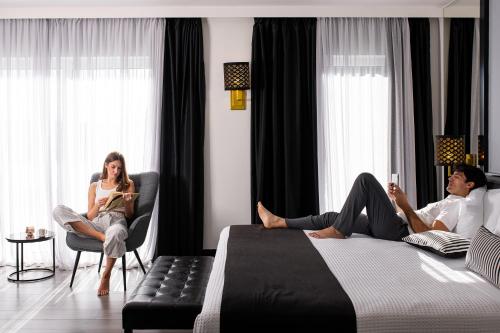 a group of people sitting in chairs in a bedroom at Athenian Riviera Hotel& Suites in Athens