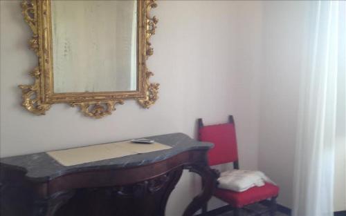 a mirror on a wall with a desk and a chair at B&B Portobello in Sestri Levante