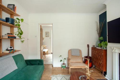 a living room with a green couch and a chair at The Cycling Cottage, Surrey Hills AONB, Dorking in Dorking