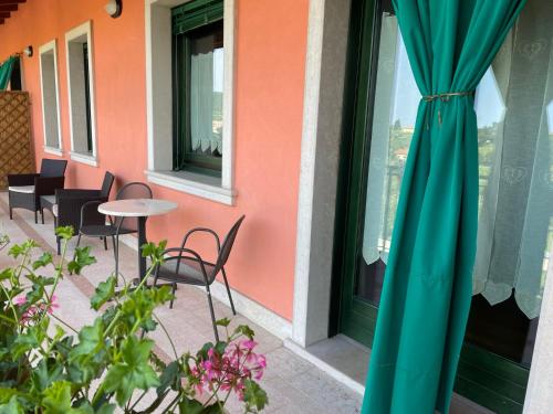 a patio with a table and chairs and a window at Al Colle in Cavaion Veronese