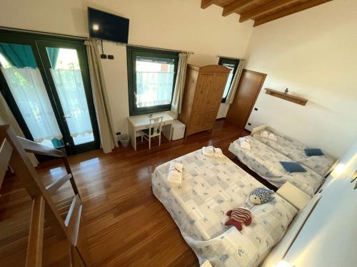 a room with two beds and a table and windows at Al Colle in Cavaion Veronese