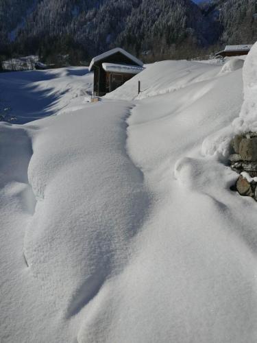 a pile of snow in front of a house at Frühstückspension Gweil in Sankt Gallenkirch