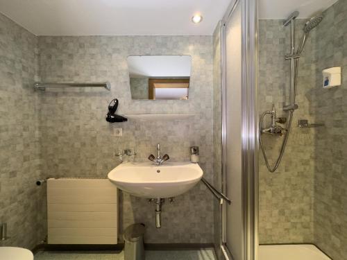 a bathroom with a sink and a shower at Frühstückspension Gweil in Sankt Gallenkirch