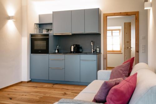a living room with a couch and a kitchen at Gasthof Grünwald in Sankt Daniel