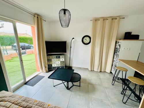un salon avec un canapé, une télévision et une table dans l'établissement Studio avec extérieur ombragé, à Saint-Marcel-lès-Valence