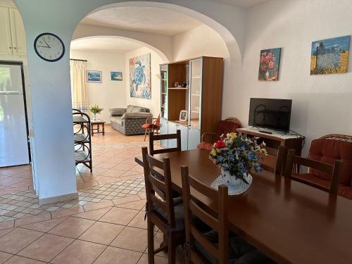 Un comedor y una sala de estar con mesa y sillas. en Villa Pinna, en San Teodoro