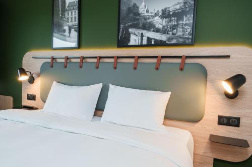 a hotel room with a bed with two white pillows at Campanile NATURE - Cahors in Cahors
