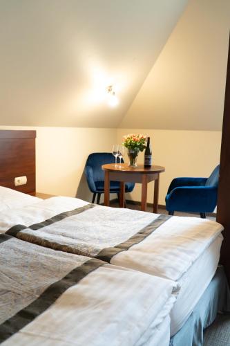a hotel room with two beds and a table with two chairs at Nad Borkiem in Kosarzyn