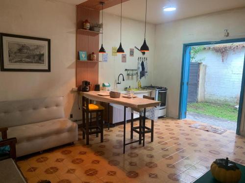 a kitchen with a table and chairs in a room at Casa aconchegante perto da praia in Guarujá