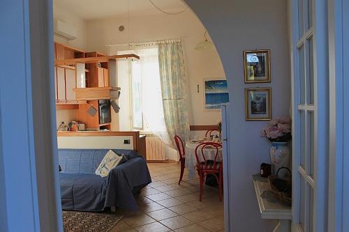 サン·ヴィンチェンツォにあるLa Casa di Vincenzoのベッドのある寝室とテーブルのあるキッチン