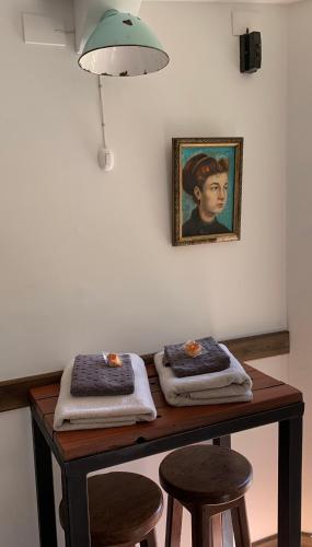 a table with two stools and a painting on the wall at Casa Azul Hostel in Puerto Varas