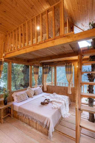a bedroom with a bed in a wooden house at The Picturesque Treehouse in Tāndi