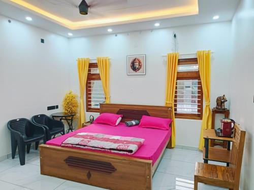 a bedroom with a large bed with pink sheets at Pepper Jazz Varkala in Varkala