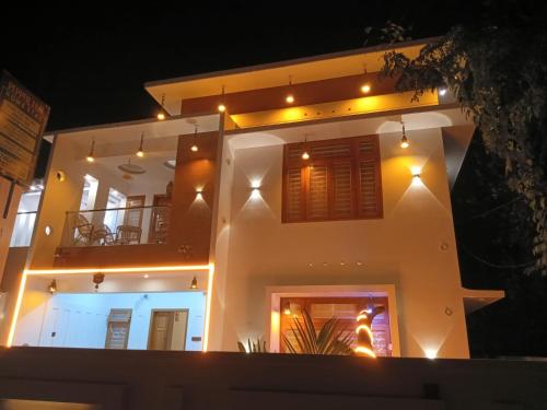 a large white house with lights on it at night at Pepper Jazz Varkala in Varkala