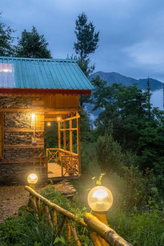 a log cabin with lights in front of it at Enchanting Cottage With Valley View By Bastiat Stays in Mandi