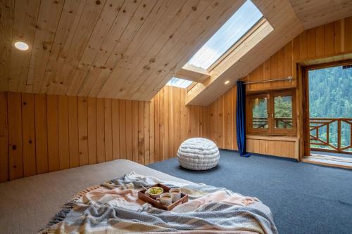 a bedroom with a bed in a room with a window at Enchanting Cottage With Valley View By Bastiat Stays in Mandi