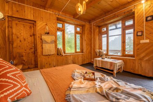 a bedroom with a bed in a wooden cabin at Enchanting Cottage With Valley View By Bastiat Stays in Mandi
