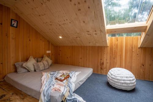 a bedroom with a bed in a wooden cabin at Enchanting Cottage With Valley View By Bastiat Stays in Mandi