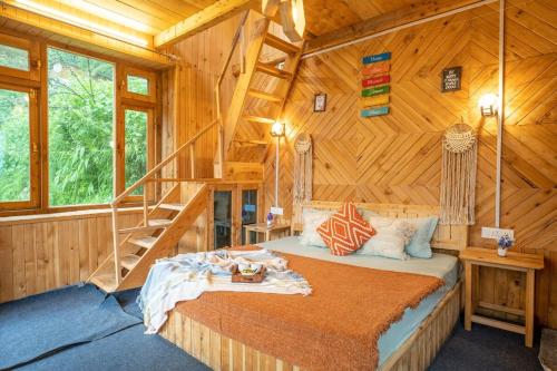 a bedroom with a bed in a wooden cabin at Enchanting Cottage With Valley View By Bastiat Stays in Mandi
