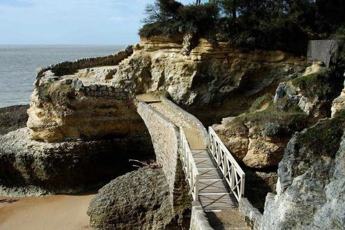 a staircase leading up to a cliff with the ocean at Mobil Home Moderne de 40m2 TOUT CONFORT Camping SIBLU Les CHARMETTES 785 La Palmyre Les Mathes in Les Mathes