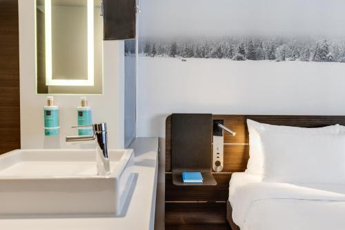 a bathroom with a sink and a bed at Novotel London Tower Bridge in London