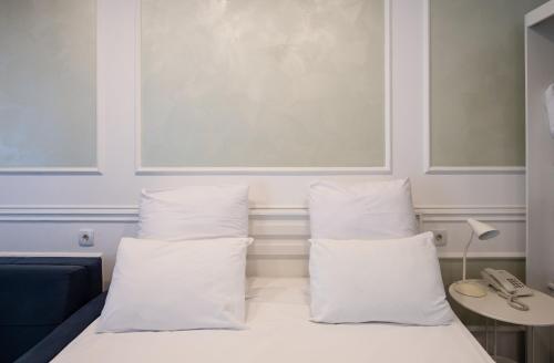a bed with white pillows in a room at Two Seasons Boutique Hotel Baku in Baku