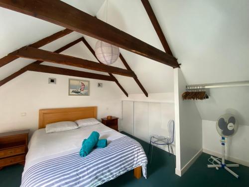 une chambre avec un lit avec des oreillers bleus dessus dans l'établissement Sue's cottages, à Pleuven