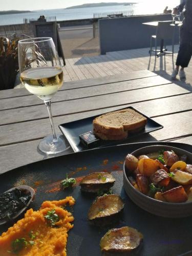 une assiette de nourriture et un verre de vin sur une table dans l'établissement Chez Jeanne, à Plouguerneau