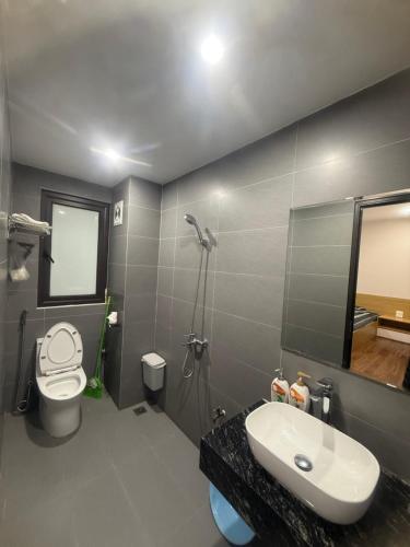 un bagno con lavandino, water e specchio di Sơn Tài a Hanoi