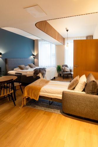 a hotel room with two beds and a couch at Postmaster Hotel in Rovaniemi