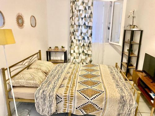 une chambre avec un lit avec une couette dessus dans l'établissement Studio à 5 mn à pied de la gare Saint-Roch, à Montpellier