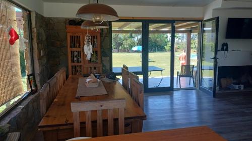 a dining room with a wooden table and a view of a yard at Tras Las Sierras in Zonda